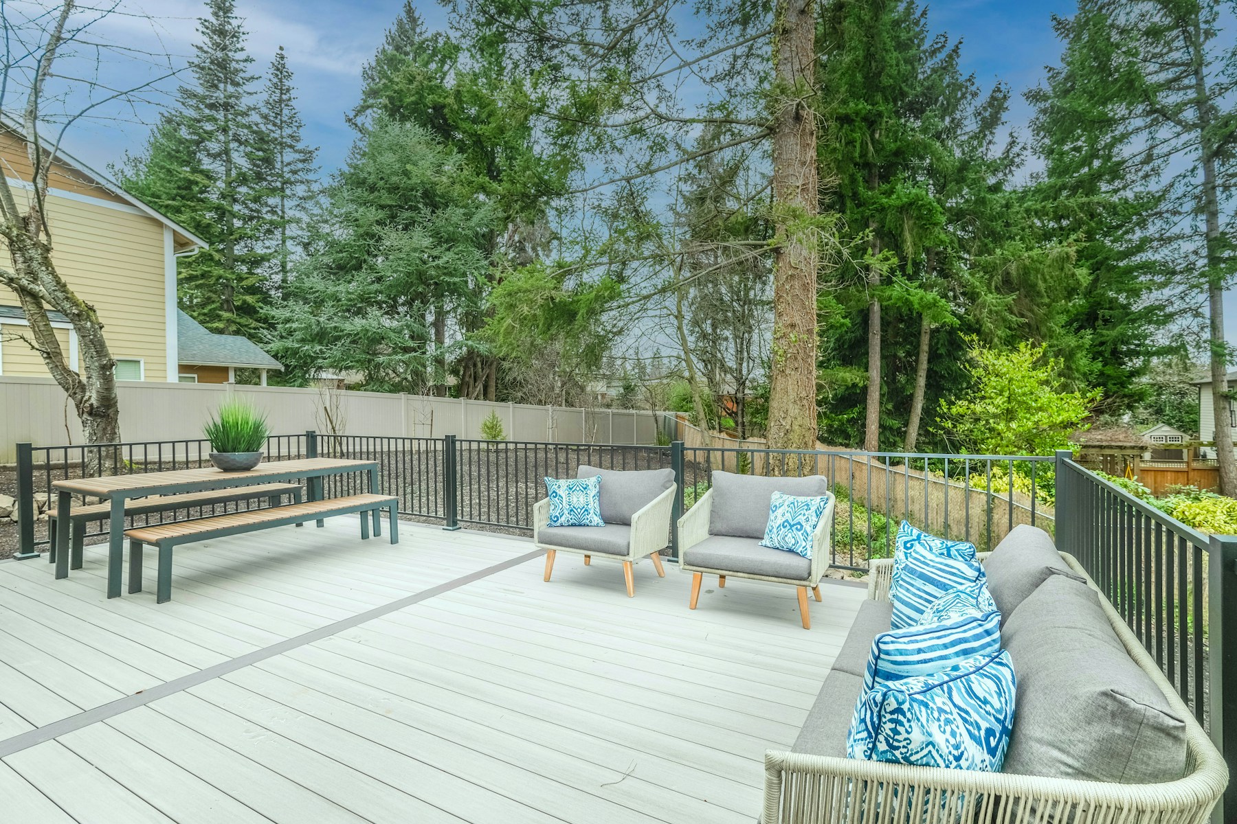 Composite deck at dusk with warm lighting in a residential backyard