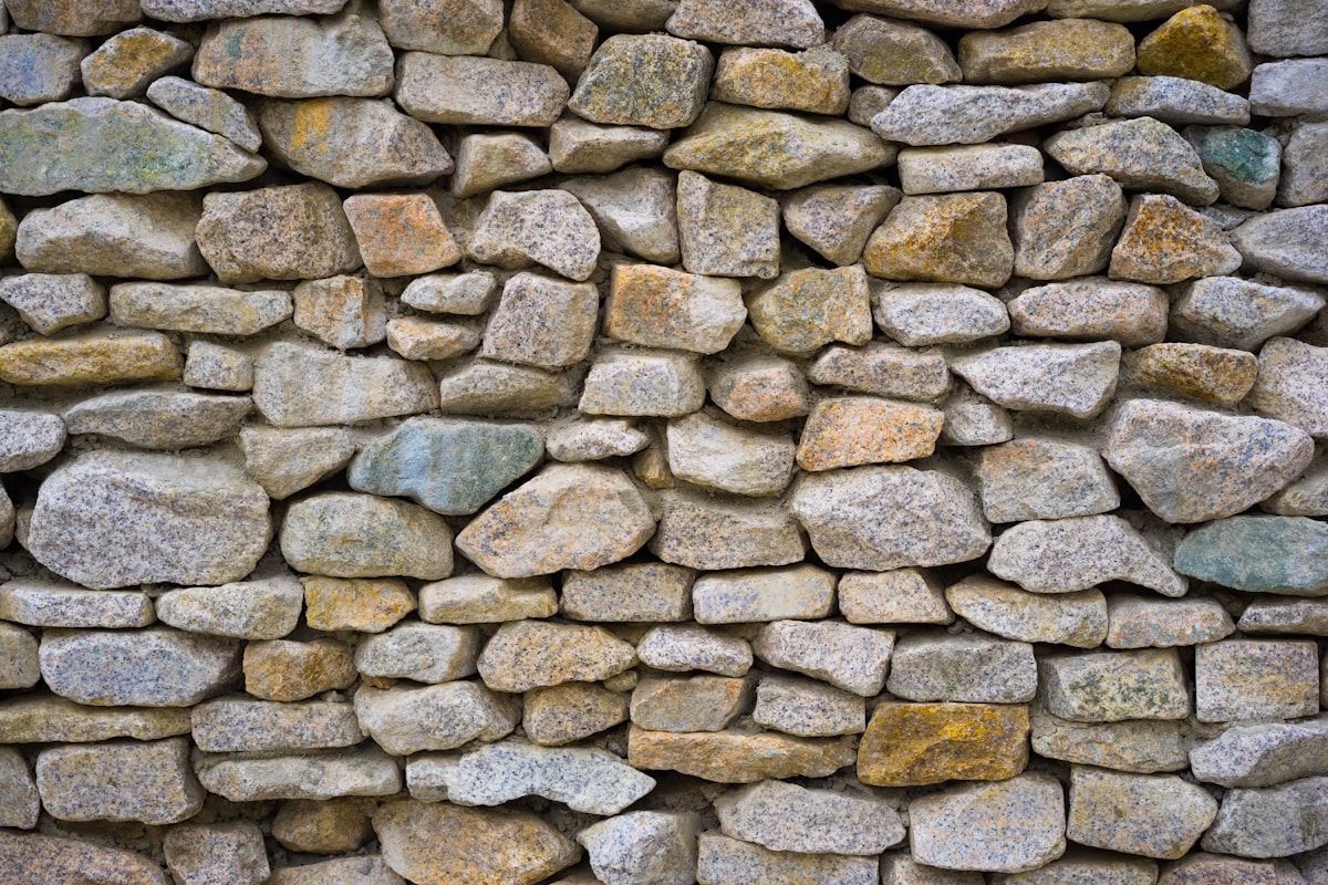Stone retaining wall stepping down a sloped backyard